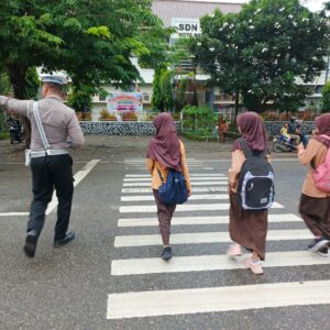 Satlantas Polres Bima Kota Aru Gatur Pagi Sambil Bantu Anak Sekolah Menyebrang Jalan
