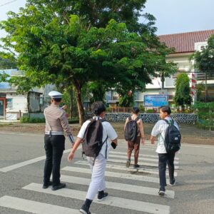 Personel Sat Lantas Polres Bima Kota Bantu Anak Sekolah Menyeberang Jalan